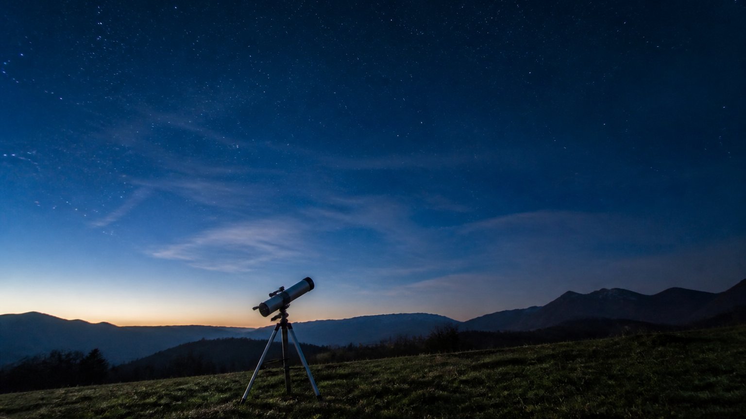 A calming night sky with a small telescope on a hill